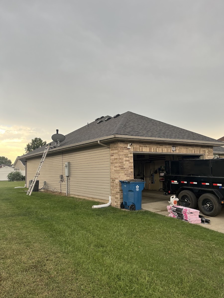 Side view of a house with roofing materials and a ladder